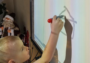 Chłopiec rysuje dom